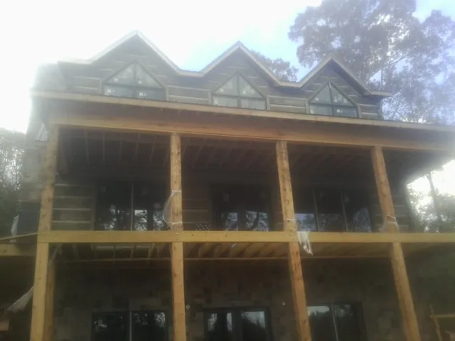 Dormers and porch framing on a large log home under construction in Snyder