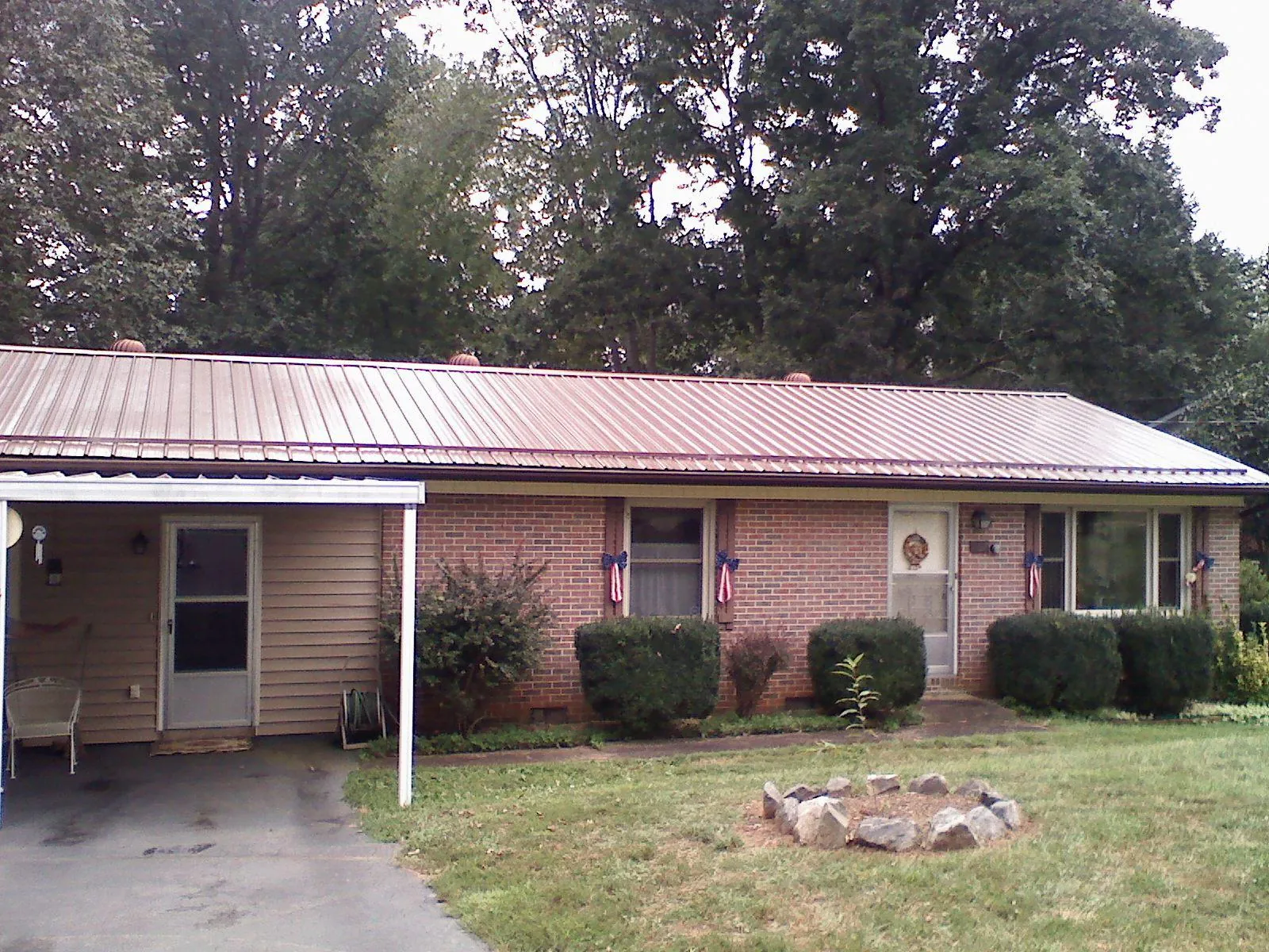 Bronze metal roof and carport on a brick ranch home — Roof Repair work by our crew in Snyder